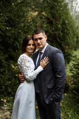wedding couple walks outside in autumn nature with a view of a wooden house. a young bride with a tall groom. wedding day