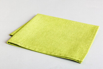 top view with green kitchen napkin isolated on table background. Folded cloth for mockup with copy...