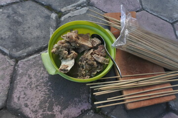Close up photo of Eid ul Adha slaughtering meat on a green  plate with bamboo sticks