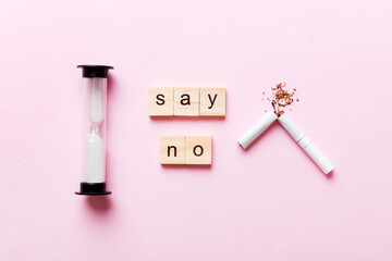 Cigarette And Wooden Blocks, Broken cigarette on table background with hourglass, No Tobacco Day with hourglass, clock health concept. time to quit smoking