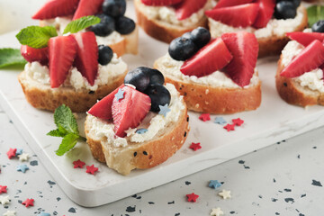 American flag sandwich with strawberries, blueberries, whipped sweet cream, soft cheese on toast bread. 4th of July American Independence Day food. Independence or Patriotic Day breakfast idea Mock up