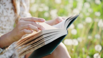 Young adult Asian woman reading a book on the lawn - Powered by Adobe
