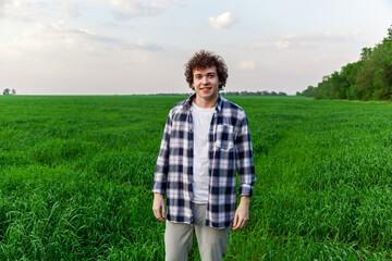 Naklejka na ściany i meble A man stands on green grass in a field