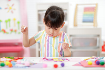 young girl making paper craft for homeschooling