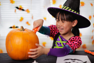 young girl was doing pumpkin carving  for halloween party at home