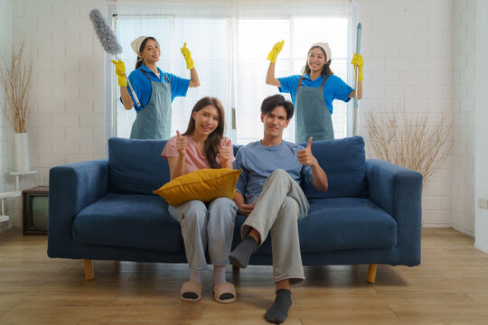Satisfied Asian homeowner gives a thumbs-up, expressing delight and approval for the exceptional cleaning service provided by the diligent Asian maid