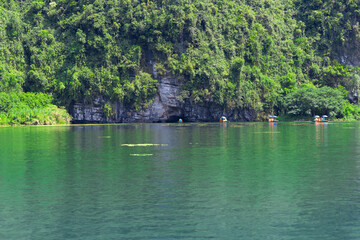 Obraz premium Trang An River Ninh Minh and Bai Dinh Mountain ranges in Vietnam only 3 hours drive from Hanoi. Beautiful winding river and large rising mountains. boats going through the caves in the river