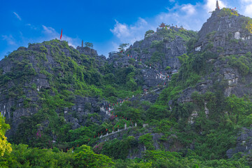Dragon Mountain in Ninh Binh Hanoi Vietnam with over 500 zigzag steps to climb to the top with magnificent views of a big dragon on the mountain peak and a small temple 