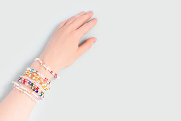 Female hand with a lot of bracelets on it. Trendy handmade jewelry made of pearls and beads on a...