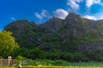 Dragon Mountain in Ninh Binh Hanoi Vietnam with over 500 zigzag steps to climb to the top with magnificent views of a big dragon on the mountain peak and a small temple 