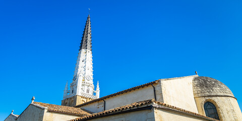 Bell tower of Saint-Etienne church in Ars-en-Ré, France a day of blue sky