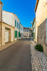 Fototapeta na wymiar Narrow street in Ars-en-Ré, France on a sunny day