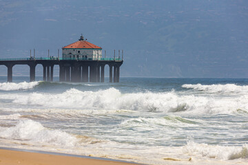 Pier at the Beach. Beach in California with pier out in to the Pacific Ocean. People walk by Beach Pier at sunny day.