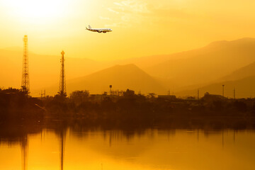 Fototapeta premium Commercial airplane above sea with sunset in summer season over beautiful scenery lagoon background, Concept business travel and transportation summer vacation travel.