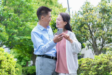 携帯を見る夫婦