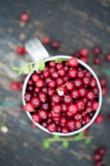 cranberry in vintage metal cup on dark background