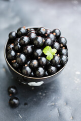 Ripe black currants in a black bowl