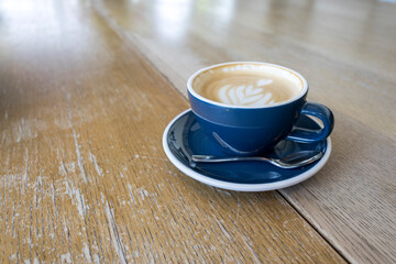 specialty coffee latte art in blue cup on a wooden table