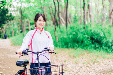 Fototapeta na wymiar 自然の中でサイクリングを楽しむ若い女性