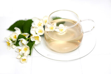 Glass cup of tea with jasmine on the white background