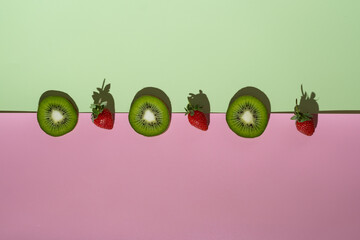 a minimalism strawberry and kiwi on white and pink background