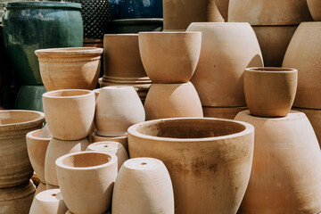 A variety of empty stacked ceramic terracotta flower pots in different sizes and shapes at the...