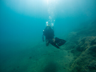 Solo diver scuba diving in the deep sea.