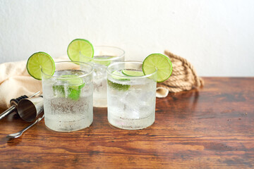 A freshly prepared gin and tonic with lemon slices and spoon on the table