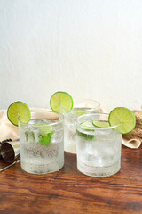 Glass of gin and tonic with mint, lime wedges and ice