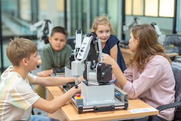 Group Kid teen child enjoy Machine Learning Robot arm is Moving Under coding Control robot at stem technology class, stem education for digital automation learn for use artificial intelligence ai