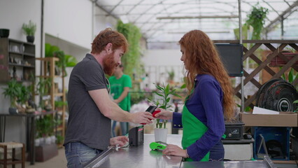 Customer Making Contactless Phone Payment for Plant at Horticulture Shop Checkout