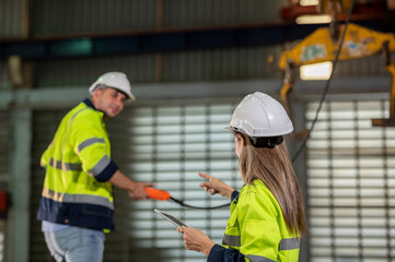 Factory apprenticeship. Woman mentor teaching man employee trainee operating machine look monitors and hand press control button process machinery. Leader foreman explaining engineer control machine