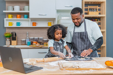 african afro black daughter kids with dad father and mom enjoy cooking class family funny internet learning by laptop . Black african family afro hair look computer for learn cooking in the kitchen