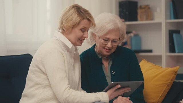 Woman and senior mother looking at family photos, mother daughter relationship
