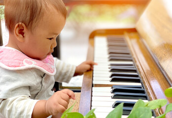 Cute Asian little girl playing piano at a music school. child development, relax music education concept