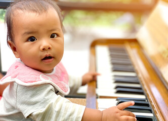 Cute Asian little girl playing piano at a music school. child development, relax music education concept
