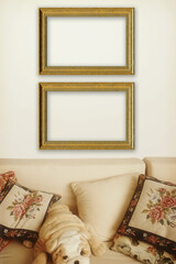 Couple of empty golden  mockup frames hanging on a white wall over a sofa with pillows and stuffed plushy dog.