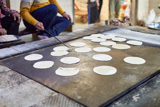 Making of chapati round flatbreads for langar in sikh gurudwara temple many uncooked roti flatbreads