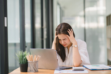 Tired frustrated young asian businesswoman feeling stressed holding head with hands, business problem failure concept.