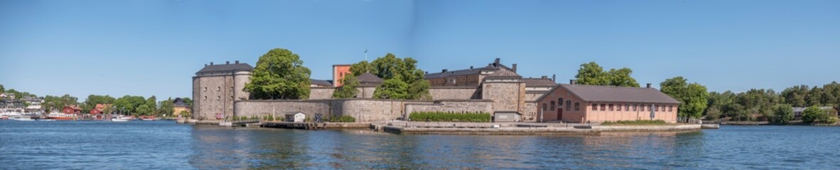 Fototapeta na wymiar Vaxholm fortress in the archipelago town Vaxholm, pier, hotel and boats, a sunny summer morning in Stockholm,