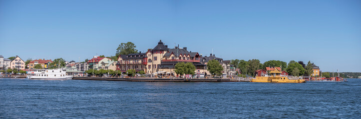 Fototapeta na wymiar Archipelago town Vaxholm, pier, hotel and boats, a sunny summer morning in Stockholm