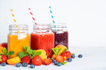 Smoothie set with fresh fruits and berries at white background. Homemade healthy drink.