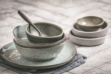 Gray stoneware plates and bowls on a rustic table, copy space - obrazy, fototapety, plakaty