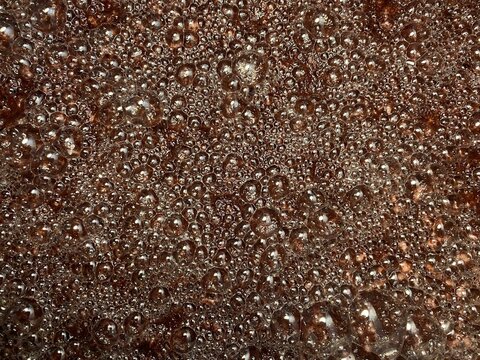 Bubbles formed on the surface of wine must caused by the residual carbon dioxide produced during the fermentation activity of yeast. Textures, close up