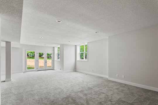 empty room with a window. freshly painted white walls and brand new nylon carpeting in the room