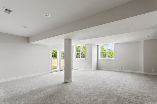 Empty Room With A Window In Finished Basement With Carpet