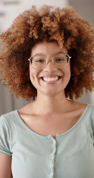 Vertical video of portrait of happy biracial woman with afro, smiling at home, slow motion