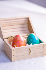 Orange and green egg in a wooden box