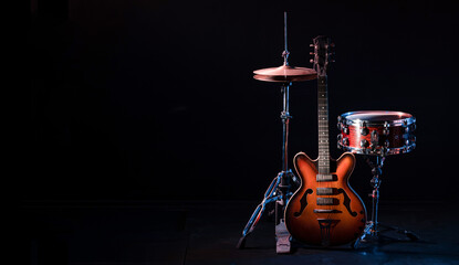 drum kit on stage on a dark background. Set of musical drums and guitars on stage.