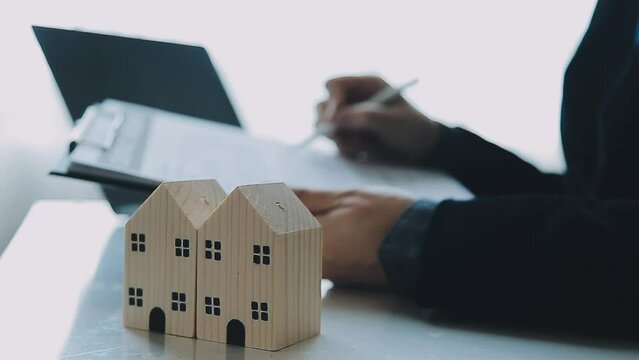 Female woman hands holding home model, small miniature white toy house. Mortgage property insurance dream moving home and real estate concept